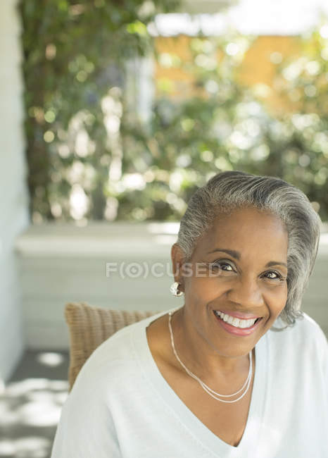 Porträt einer lächelnden Seniorin auf der Veranda — Stockfoto