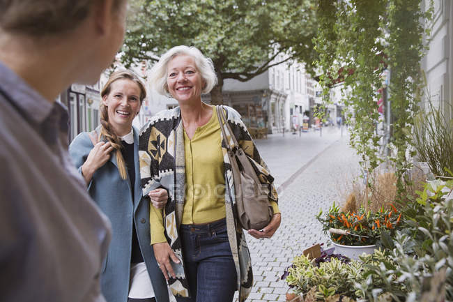 Mother and daughter smiling at florist at storefront — Stock Photo