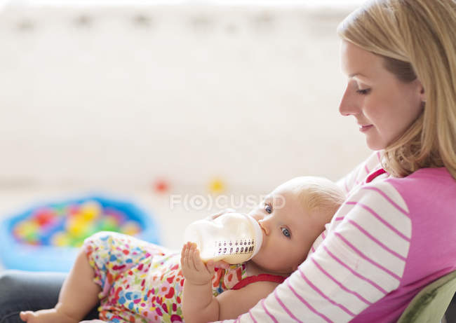 Madre alimentación bebé niña de biberón - foto de stock