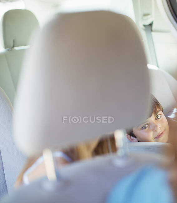 Mère se retournant pour parler aux enfants sur le siège arrière de la voiture — Photo de stock