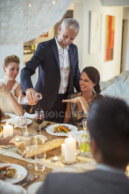 Hombre sirviendo vino en la cena - foto de stock
