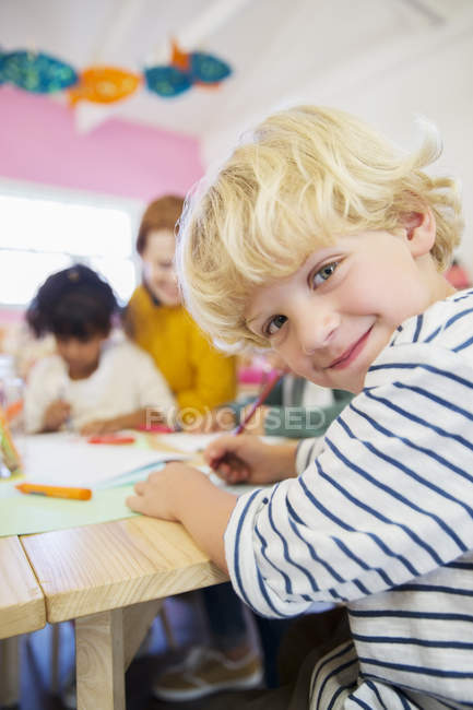 Student drawing in classroom and looking at camera — Stock Photo
