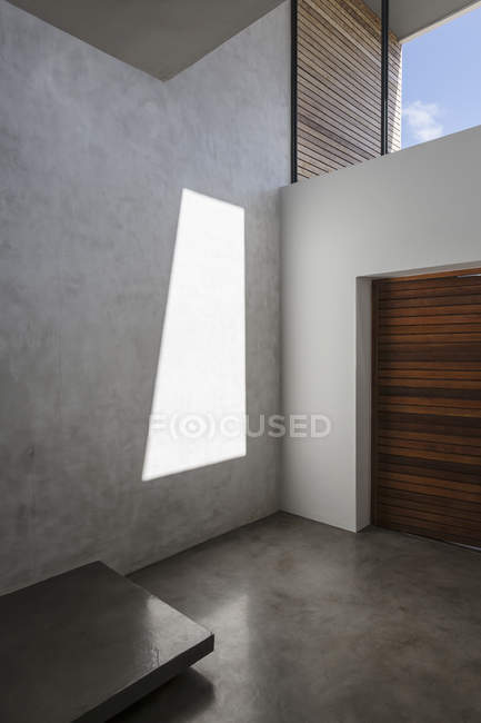 Sunshine casting reflection on modern, concrete home showcase interior wall — Stock Photo