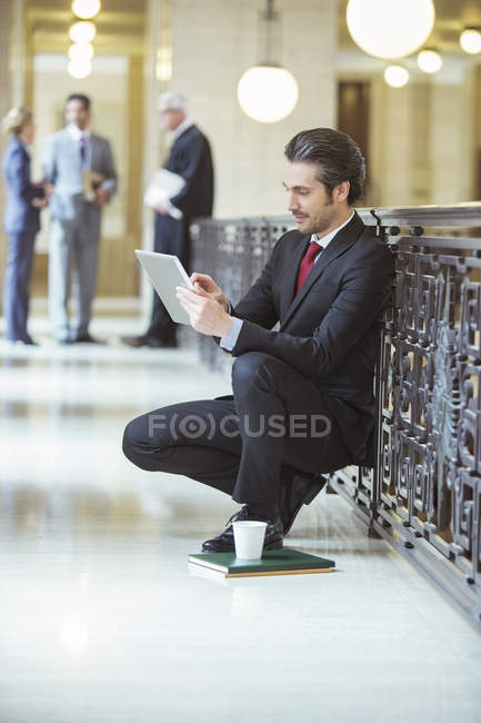 Адвокат працює над цифровим планшетом у будівлі суду — стокове фото