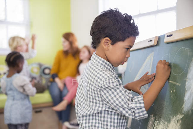 Schüler zeichnen auf Kreide im Klassenzimmer — Stockfoto