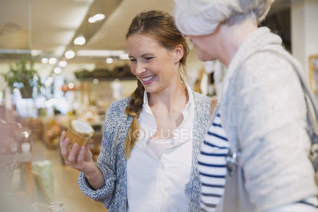 Улыбающиеся мать и дочь делают покупки в магазине — стоковое фото