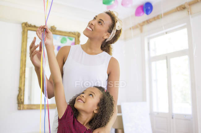 Mother and daughter holding balloons together — Stock Photo