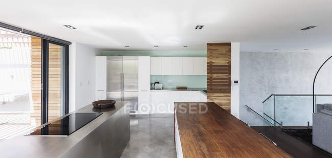 Moderna, minimalista casa escaparate cocina interior con mostradores de madera y acero inoxidable - foto de stock