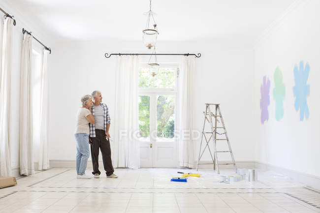 Couple plus âgé regardant des échantillons de peinture ensemble — Photo de stock