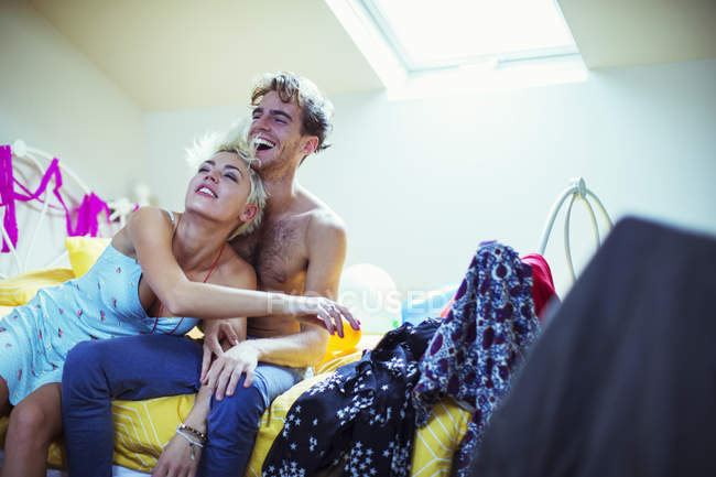 Ridere coppia abbracciare sul letto a casa — Foto stock