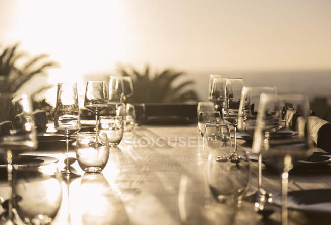 Bicchieri sul tavolo soleggiato patio tramonto — Foto stock