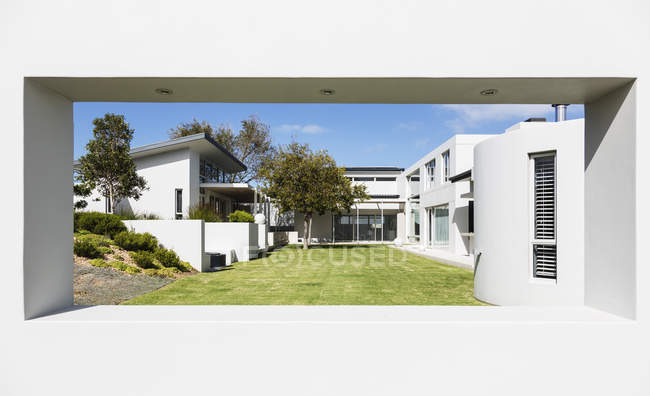 Maison de luxe moderne ensoleillée vitrine extérieure et cour — Photo de stock