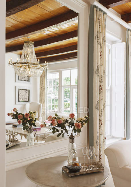 Роскошная гостиная с цветами на фоне зеркала — стоковое фото