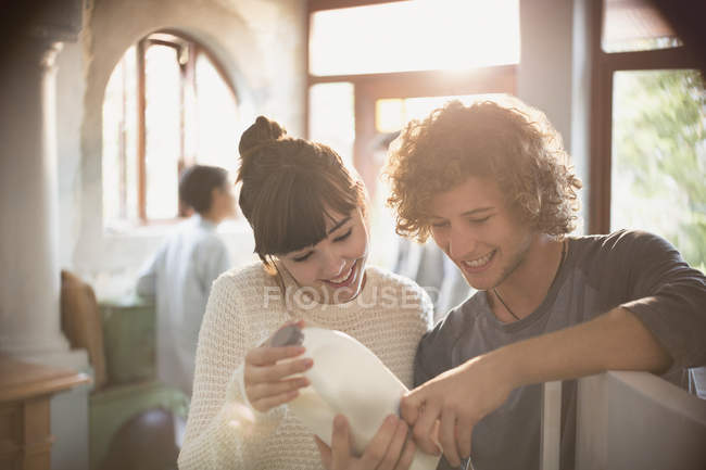 Jovens companheiros de quarto casal olhando para a data de validade no leite na cozinha — Fotografia de Stock