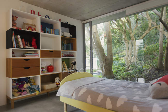 Домашня вітрина інтер'єру дитячої спальні з видом на дерева в саду — стокове фото