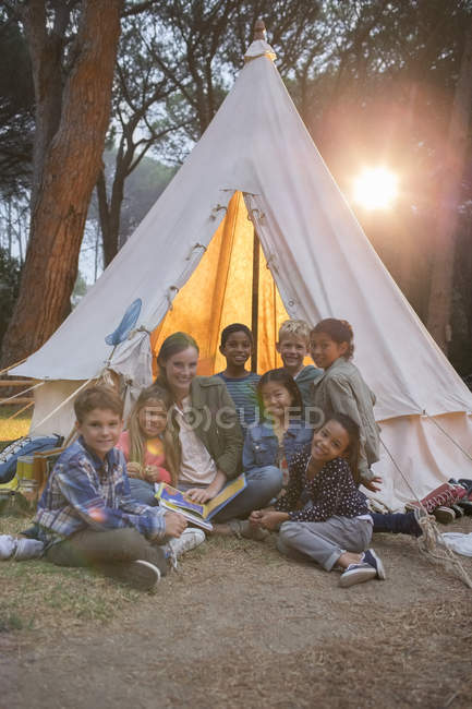 Profesores y estudiantes sonriendo en el camping - foto de stock