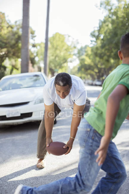 Grand-père et petit-fils jouant au football dans la rue — Photo de stock