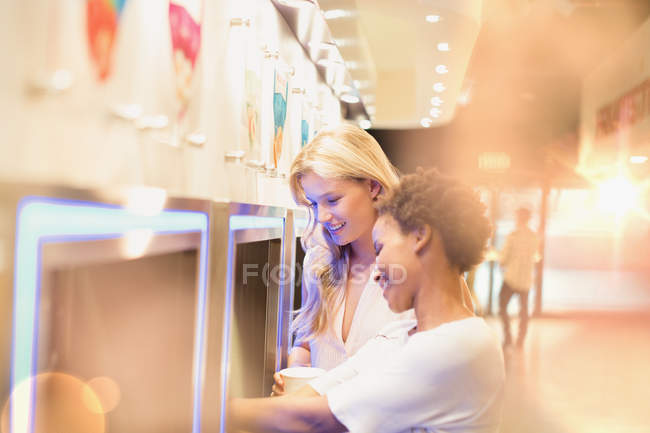 Jeunes femmes amies au yaourt glacé libre-service sur le marché — Photo de stock