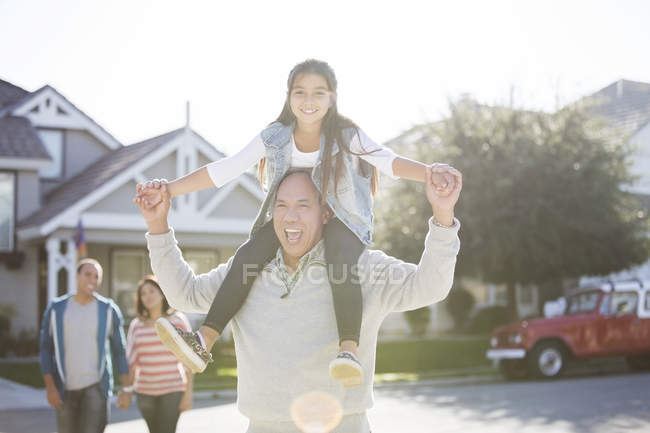 Portrait of grandfather carrying granddaughter on shoulders — Stock Photo