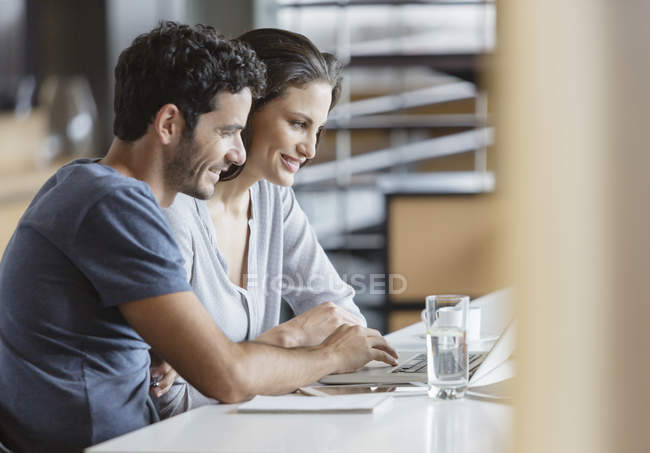 Feliz casal caucasiano usando laptop na mesa — Fotografia de Stock