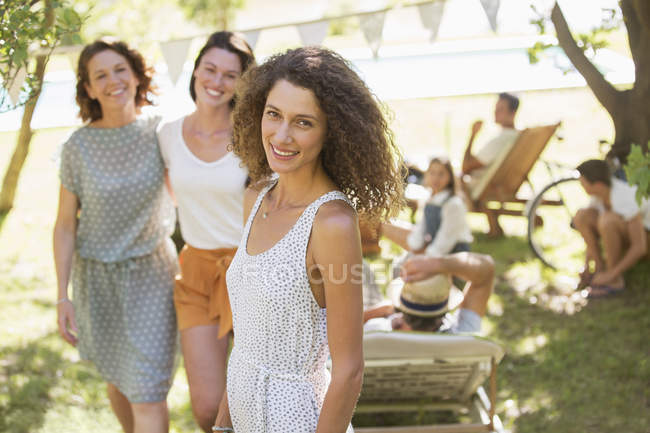 Felice bella donna sorridente all'aperto con la famiglia vicino — Foto stock