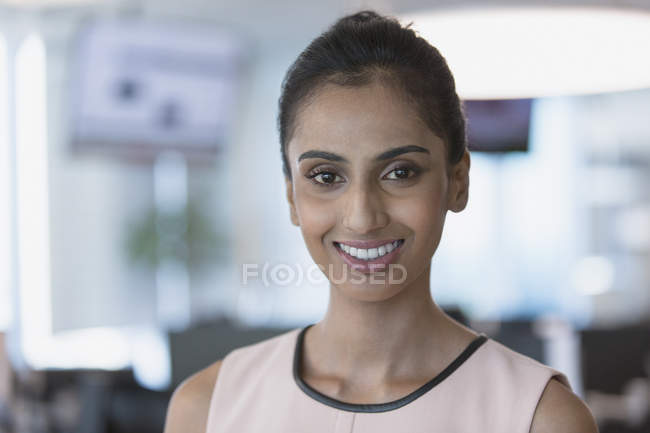 Porträt lächelnde, selbstbewusste Geschäftsfrau vor verschwommenem Hintergrund — Stockfoto