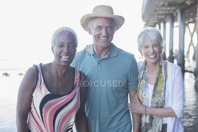 Portrait of happy senior friends at beach — Stock Photo