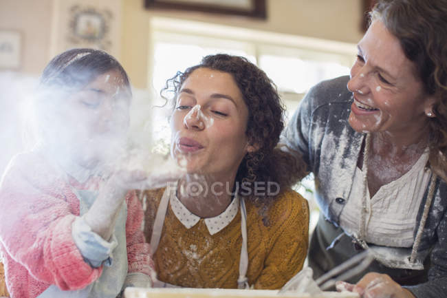 Tres generaciones de mujeres jugando con harina - foto de stock