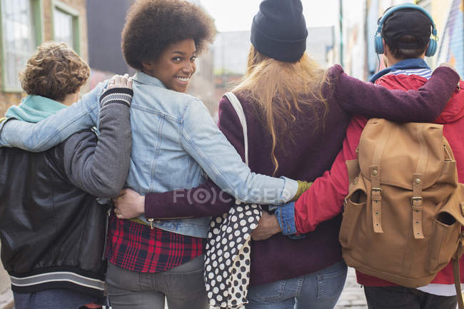 Visão traseira de amigos andando juntos na rua da cidade — Fotografia de Stock