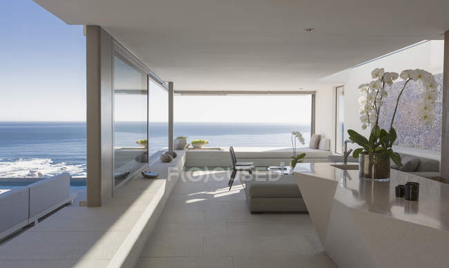 Сучасна, розкішна домашня вітрина інтер'єру вітальні з сонячним видом на океан — стокове фото