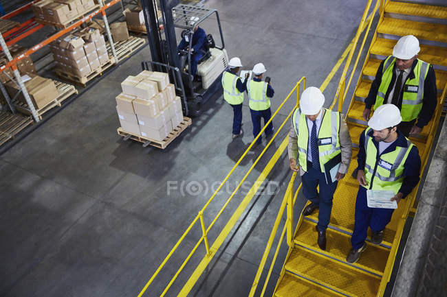 Forklift, managers and workers in distribution warehouse — Stock Photo