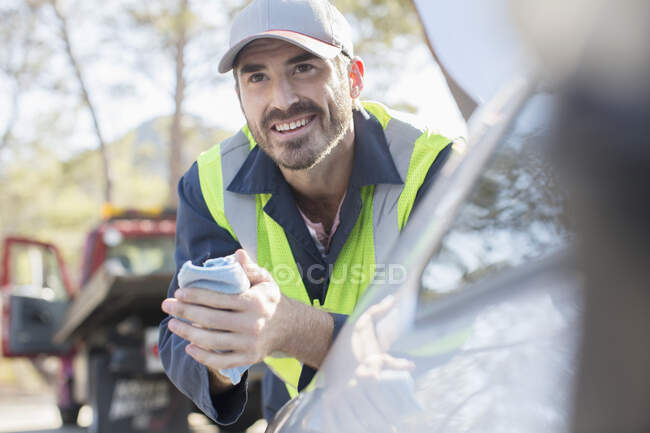 Roadside mechanic leaning on car — Stock Photo