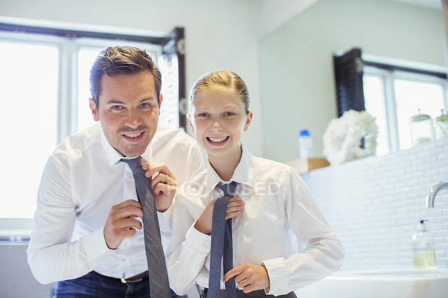 Padre e hija ajustando lazos en el baño - foto de stock