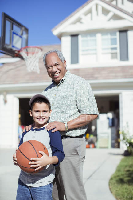 Portrait of smiling grandfather and grandson in sunny driveway — Stock Photo