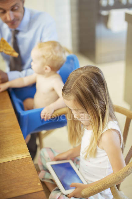 Girl using digital tablet at table — Stock Photo