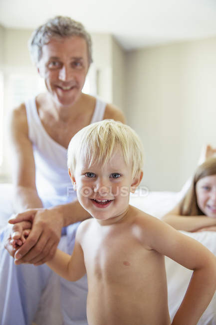Отец и дети на кровати — стоковое фото