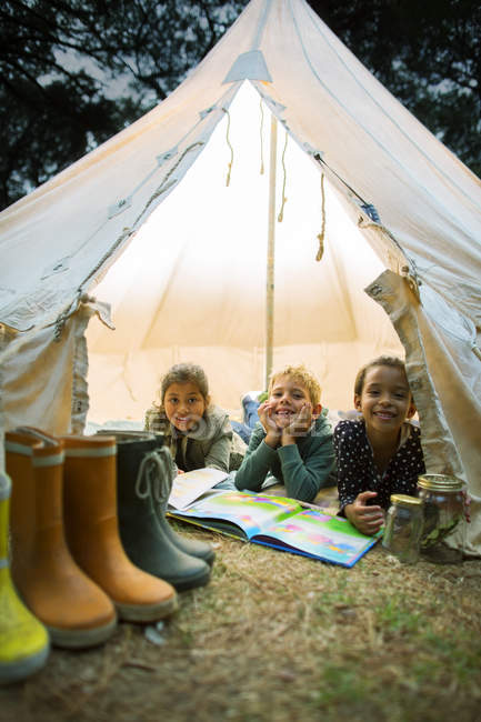 Children smiling in tent at campsite — Stock Photo