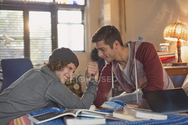 Young men friends arm wrestling — Stock Photo