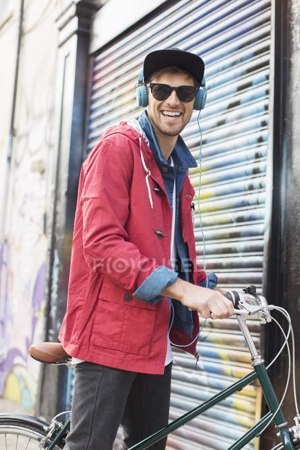 Чоловік штовхає велосипед на міську вулицю — стокове фото