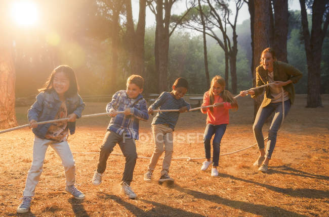 Schüler und Lehrer spielen Tauziehen im Wald — Stockfoto