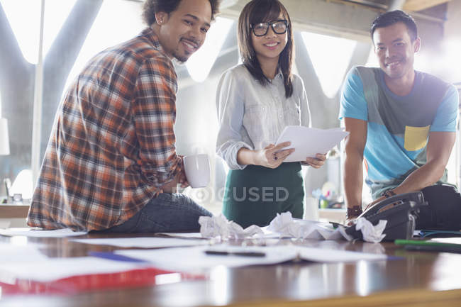 Retrato de gente de negocios creativa feliz con papeleo en la reunión - foto de stock