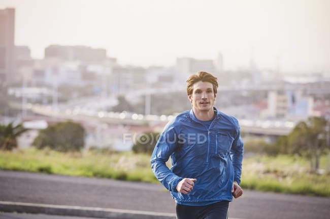 Чоловік біжить по міській вулиці міста — стокове фото