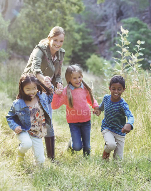Students and teacher walking in field — Stock Photo