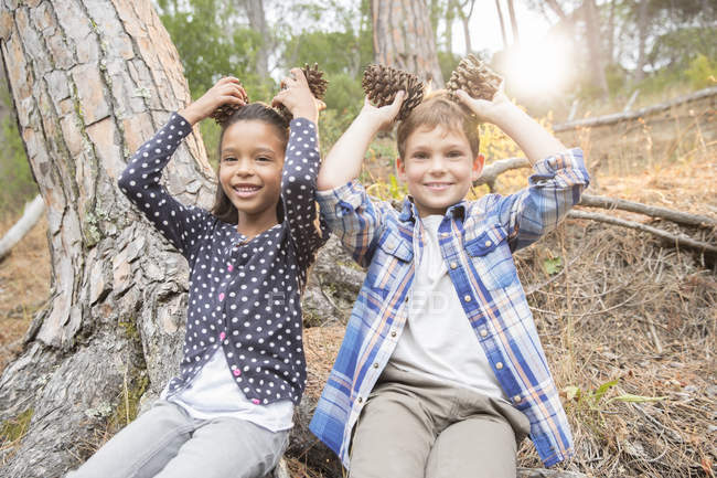 Bambini che giocano con pigne nella foresta — Foto stock