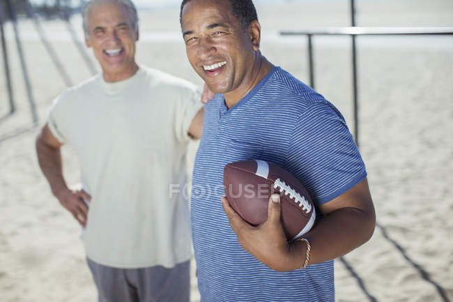 Портрет літніх чоловіків з футболом на пляжі — стокове фото