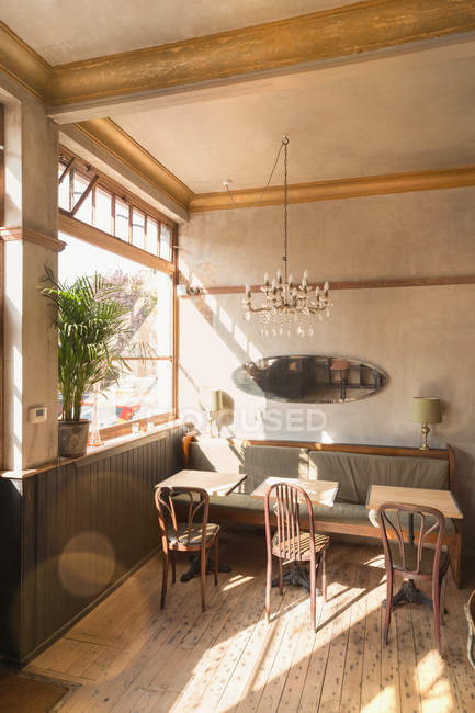 Деревянный стол со стульями и кабинкой в пустом винтажном кафе — стоковое фото
