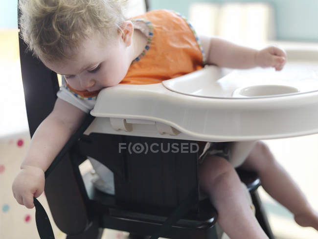 Menina bebê jogando em cadeira alta — Fotografia de Stock