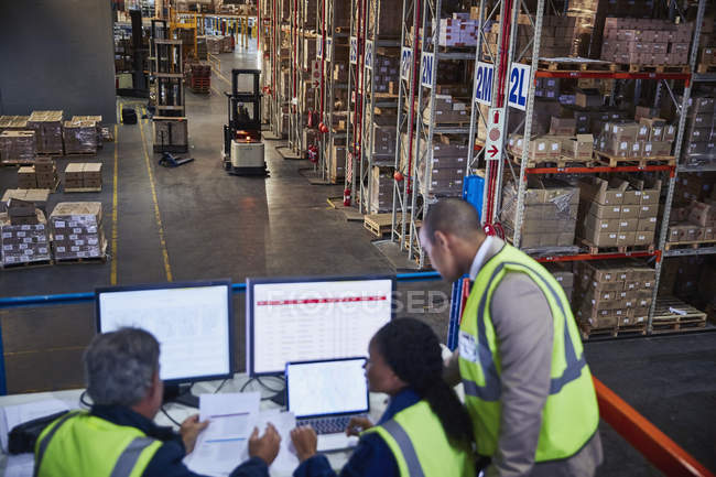 Managers working meeting at laptop and computers in distribution warehouse — Stock Photo
