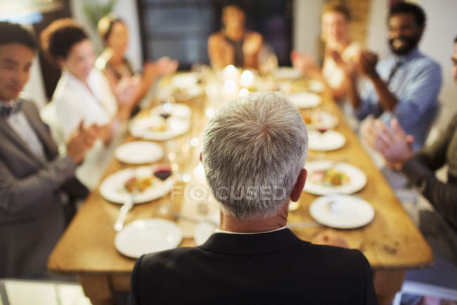 Amigos aplaudiendo en la cena - foto de stock
