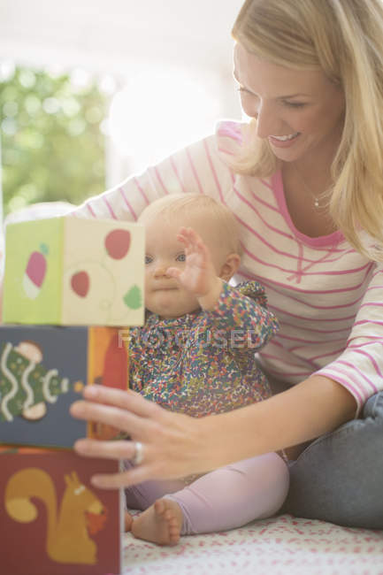 Mother playing with baby girl on floor — Stock Photo